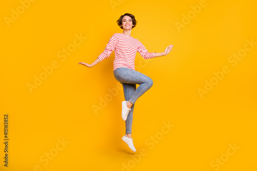 Fototapeta Naklejka Na Ścianę i Meble -  Full size photo of young attractive lovely pretty cheerful smiling positive girl jumping isolated on yellow color background