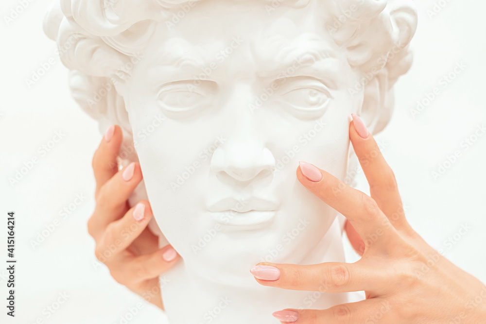 Women's hands gently touch the cheek of the sculpture of a man.Creative concept.Contemporary Art.