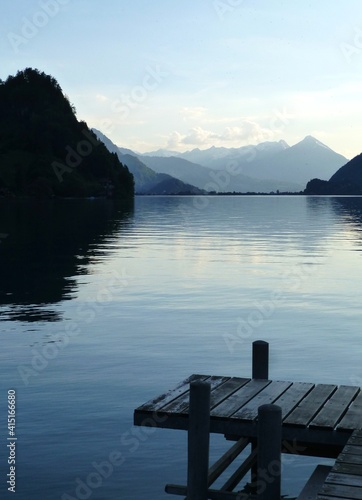 Post-sunset view over Brienzersee looking towards Interlaken and Niesen mountain from Iseltwald, with wooden jetty in foreground