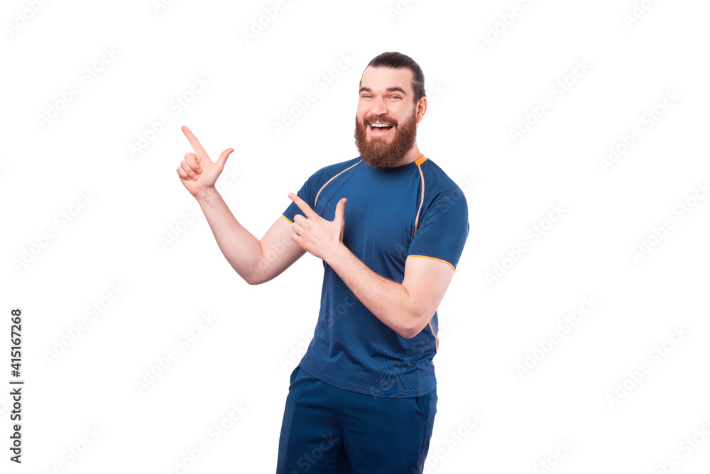 Smiling young fitness man pointing away over white background. Smiling young fitness man pointing away over white background.