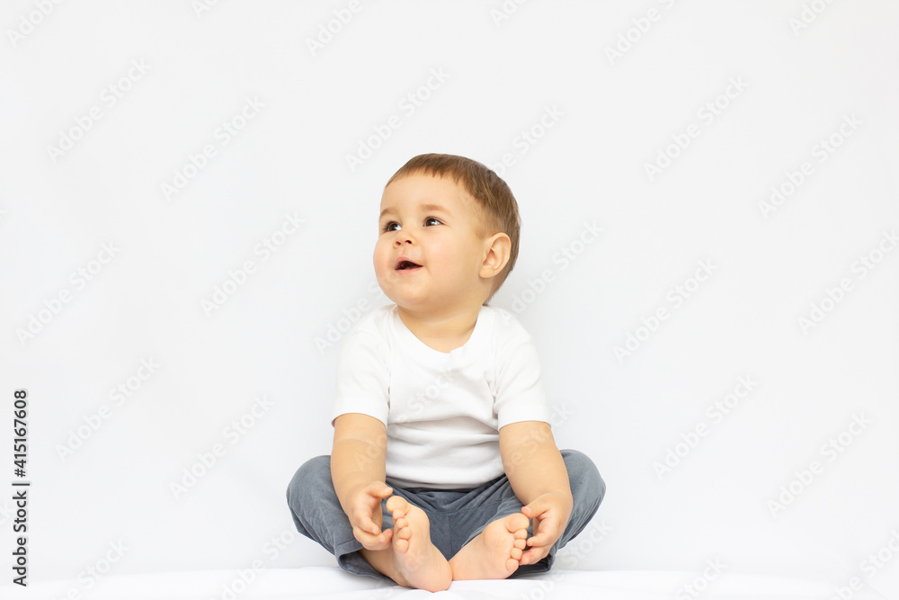Cute little boy sitting isolated on white background. looking up concept.