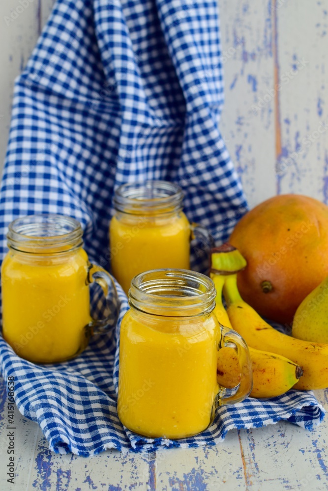 tropical yellow smoothie in a glass with mango, pear and banana tropical yellow smoothie in a glass with mango, pear and banana