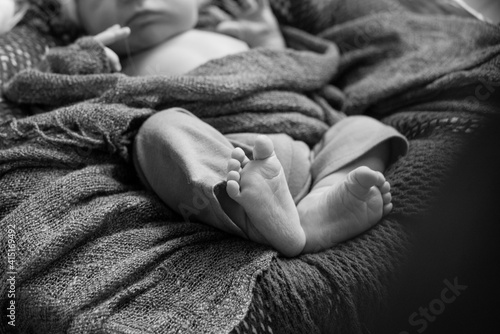 Cute little baby feet in mom's arms. Happy motherhood 