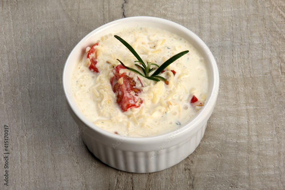 One pot with casserole - sour cream, tomatoes and fish or other ingredients before baking. dishes with unroasted julienne One pot with casserole - sour cream, tomatoes and fish or other ingredients before baking. dishes with unroasted julienne