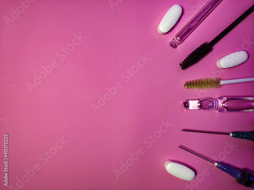 Medicine and cosmetology items close-up on a pink background.