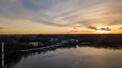 Aerial view of a beautiful and dramatic sunset over a forest lake reflected in the water  landscape drone shot. Blakheide  Beerse  Belgium. High quality photo