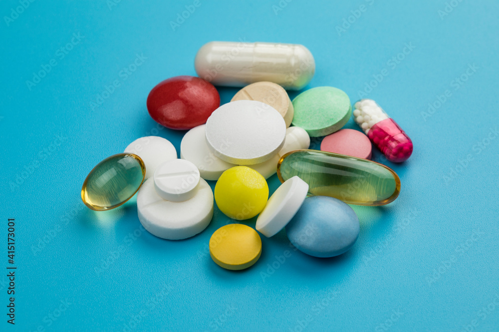 Multicolored tablets on blue background. Health care concept. Multicolored tablets on blue background. Health care concept.