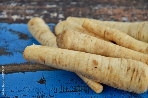 raw and uncooked parsnips on a blue wooden table