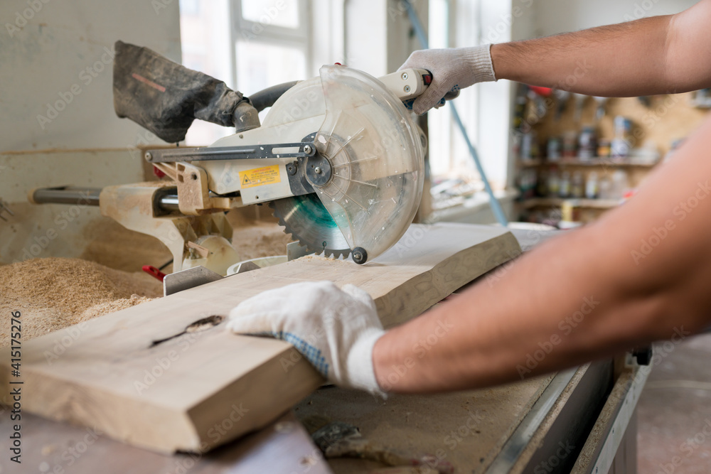 Carpenter working on wood with electric jigsaw in workshop. Joinery work on the production of wooden furniture. Small Business Concept Carpenter working on wood with electric jigsaw in workshop. Joinery work on the production of wooden furniture. Small Business Concept