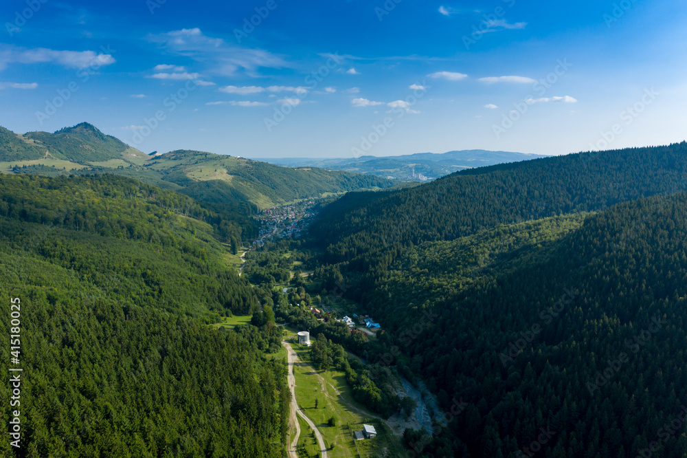 A valley between two forested mountains, in the Southern Carpathians. Aerial view