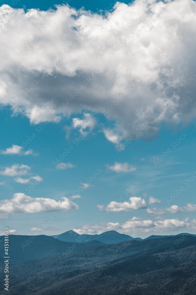 Summer landscape in mountains and the dark blue sky with clouds