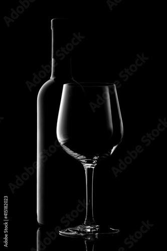 red wine bottle and wine glass isolated on black background