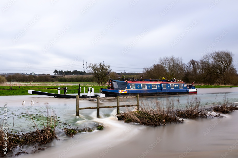 Canal boat stuck trapped in flooded high river overflowing lock with ...