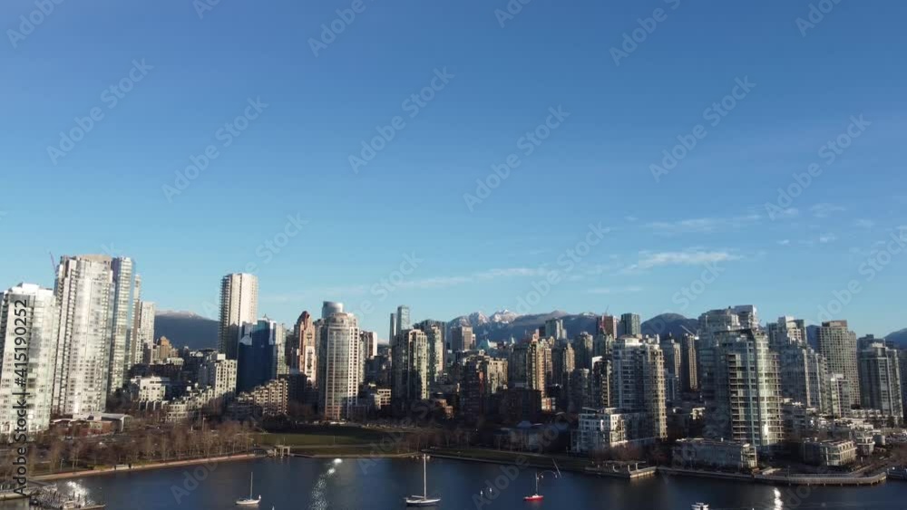 Closing shot of Vancouver downtown on a sunny day with yachts in front Closing shot of Vancouver downtown on a sunny day with yachts in front