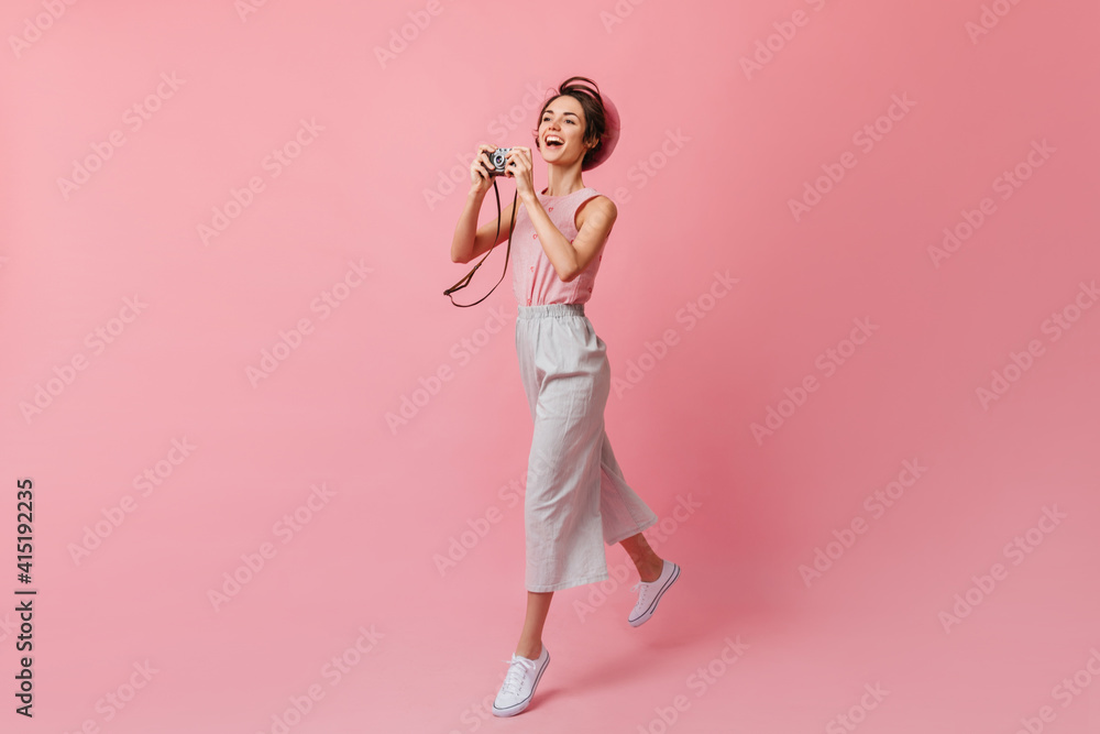 Inspired french girl with camera looking away. Good-looking slim woman in pants dancing on pink background. Inspired french girl with camera looking away. Good-looking slim woman in pants dancing on pink background.