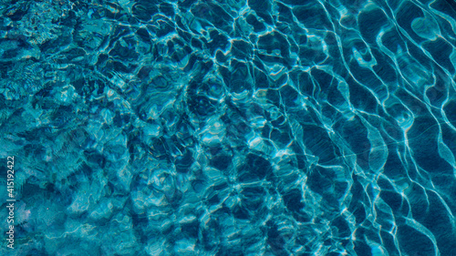 Abstract pool water. Swimming pool bottom caustics ripple and flow with waves background surface of blue swimming pool