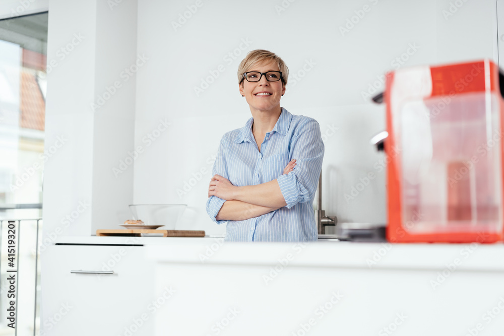 Attractive housewife standing in her kitchen Attractive housewife standing in her kitchen