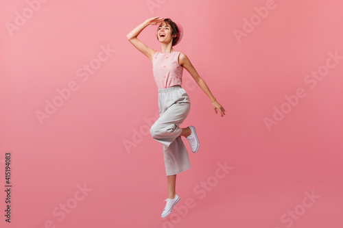 Positive girl in white shoes jumping and looking away. Full length view of jocund french lady in beret.