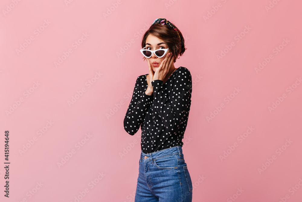 Amazed slim girl touching face with hands. Studio shot of attractive lady with short haircut isolated on pink background. Amazed slim girl touching face with hands. Studio shot of attractive lady with short haircut isolated on pink background.