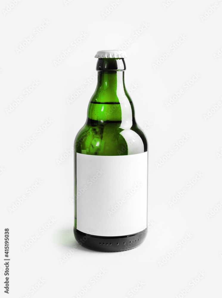 Green beer bottle with blank label. Template for placing your design. Vertical shot. Green beer bottle with blank label. Template for placing your design. Vertical shot.