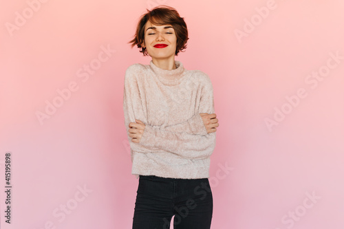 Fotografia Pleasant woman in sweater posing with closed eyes