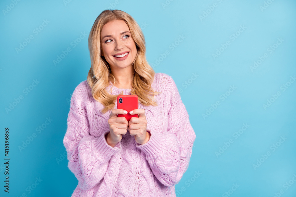 Photo portrait of blonde woman browsing internet with smartphone looking copyspace isolated vivid blue color background Photo portrait of blonde woman browsing internet with smartphone looking copyspace isolated vivid blue color background