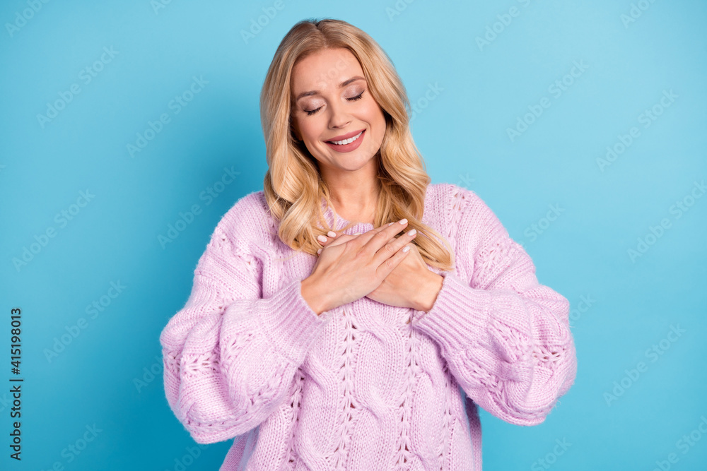 Photo portrait of blonde woman keeping hands on chest smiling thankful closed eyes isolated vibrant blue color background Photo portrait of blonde woman keeping hands on chest smiling thankful closed eyes isolated vibrant blue color background