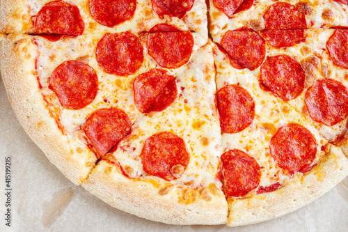 Tasty classic pepperoni pizza. Fresh sliced pizza on baking paper