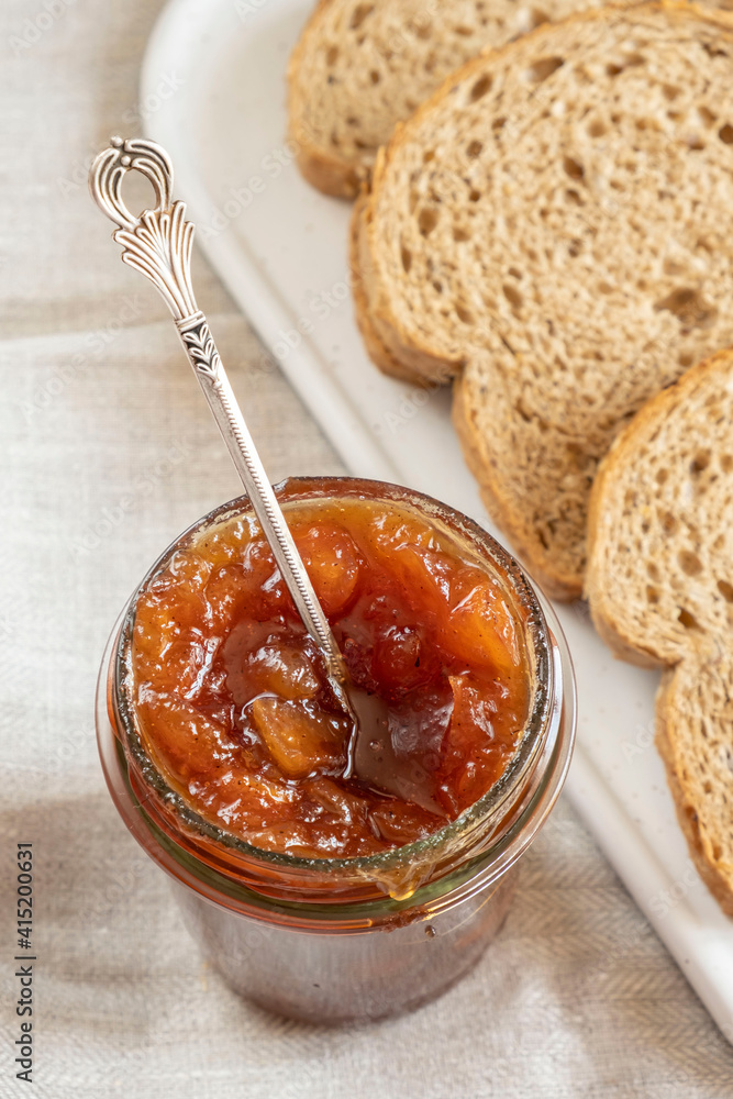 Homemade apple jam marmalade with cloves and cinnamon from organic apples in glass jar and wholemeal bread near vintage teaspoon. Homemade autumn jam preserves. Apple jam sandwich toast breakfast Homemade apple jam marmalade with cloves and cinnamon from organic apples in glass jar and wholemeal bread near vintage teaspoon. Homemade autumn jam preserves. Apple jam sandwich toast breakfast