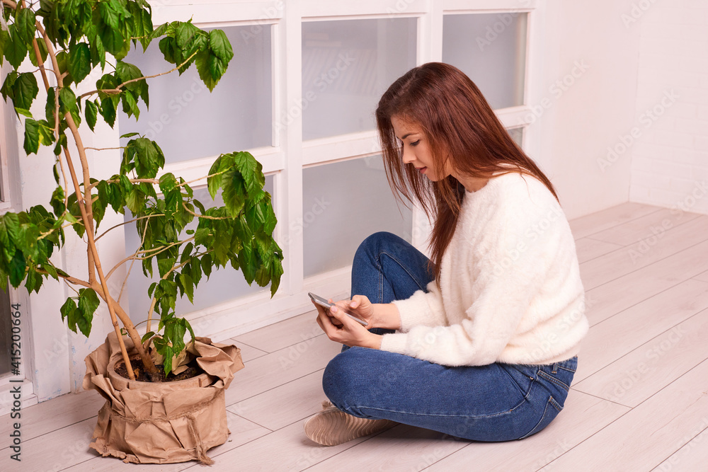 woman in home greenhouse looking for information on plant care woman in home greenhouse looking for information on plant care