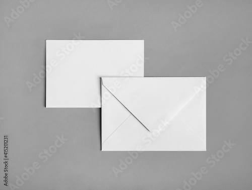 Two blank paper envelopes on gray paper background. Back and front. Flat lay.