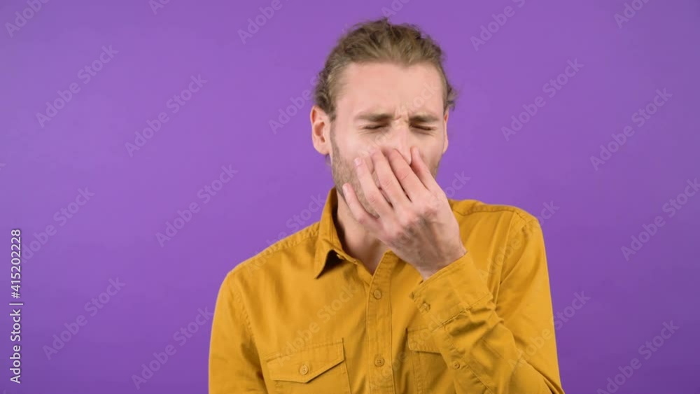 man on isolated purple background pinches his nose with his fingers. 4K man on isolated purple background pinches his nose with his fingers. 4K