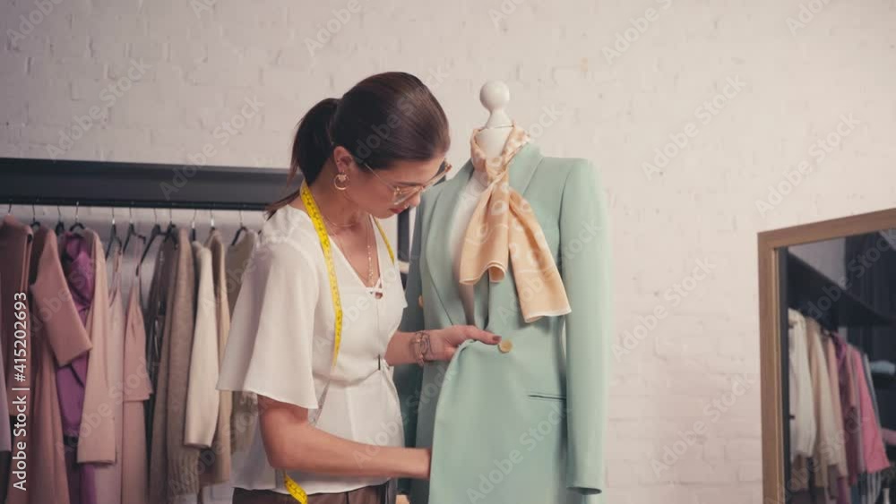 Designer working with jacket on mannequin Designer working with jacket on mannequin