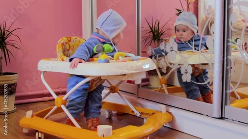 baby near the mirror,the first time a baby sees a mirror, a baby near a wardrobe with a mirror photo