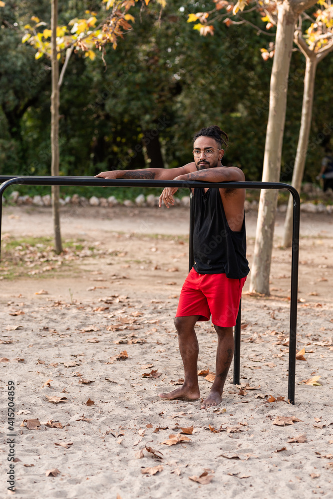 african american athlete boy does calisthenics fitness exercises on bars in park african american athlete boy does calisthenics fitness exercises on bars in park