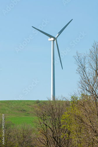 wind mill on top of a grass covered hill