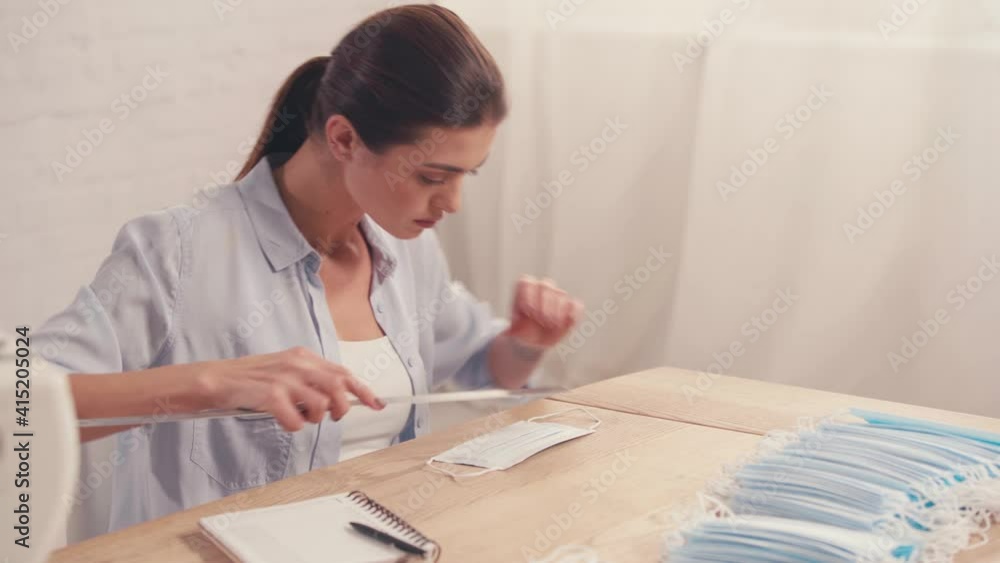 Seamstress measuring medical mask at table Seamstress measuring medical mask at table