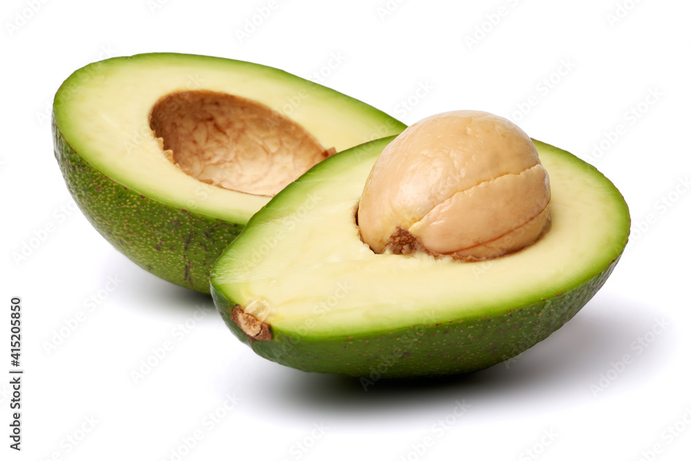 Halved Green avocado with seed isolated on a white background with clipping path Halved Green avocado with seed isolated on a white background with clipping path