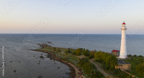 Aerial shot of a lighthouse on the Kihnu island in Estonia during a beautiful sunset photo