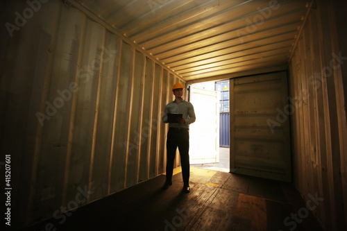 Engineer or supervisor checking and control loading Containers box from Cargo at harbor.Foreman control Industrial Container Cargo freight ship at industry.Transportation and logistic concept.