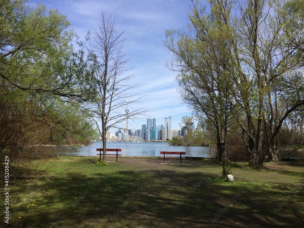 Obraz premium Empty benches facing skyline of downtown Toronto. Toronto islands, Ontario, Canada. 