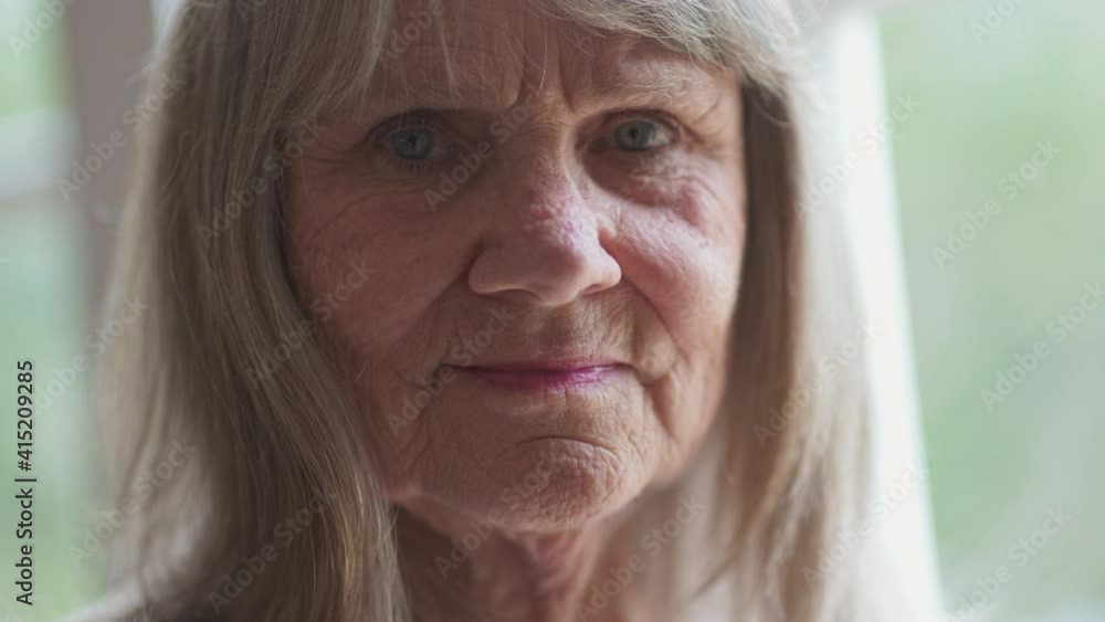 Close up portrait of friendly looking senior Caucasian woman looking at ...
