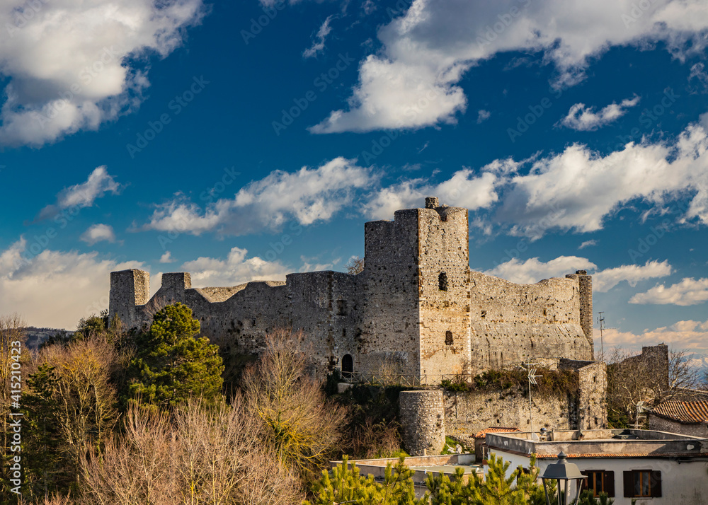 The small medieval village of Castel San Pietro Romano, Lazio, province of Rome, Palestrina. The remains of the ancient medieval castle, with its towers and stone and brick walls. Blue sky with clouds