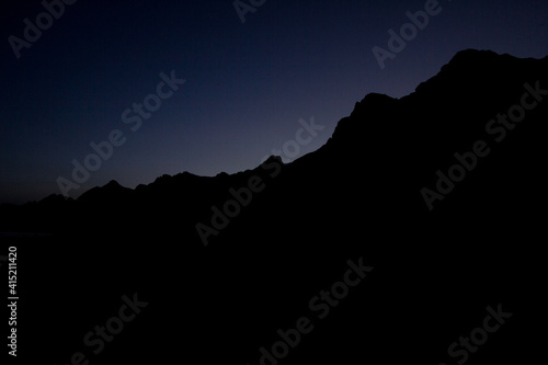 mountain silhouette at sunset in dim light