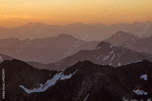 layered mountain ranges in golden sunrise light in switzerland grisons engadin