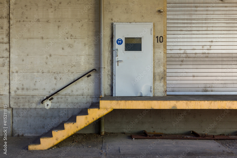 delivery bay entrance in industrial building with door and stairs leading up to it