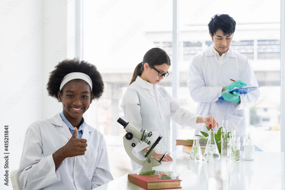 Asian teacher and diverse student doing tests of plants in classroom. Group of diversity scientists learning science and doing analysis for germs and bacteria with microscope in the laboratory Asian teacher and diverse student doing tests of plants in classroom. Group of diversity scientists learning science and doing analysis for germs and bacteria with microscope in the laboratory