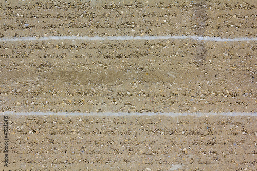 Photos closeup of layers of rammed earth construction