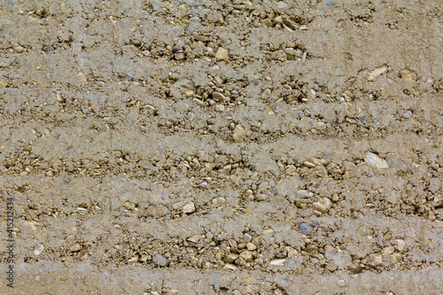 closeup of rammed earth wall construction with clay and gravel