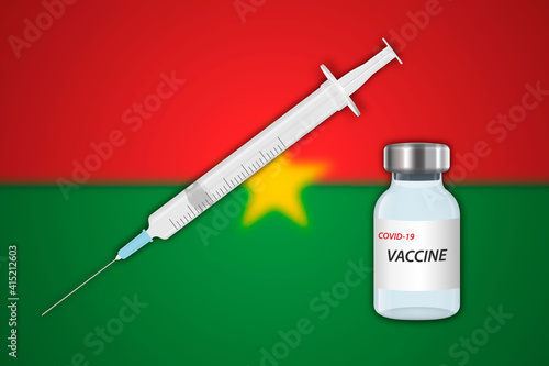 Syringe and vaccine vial on blur background with Burkina Faso flag,